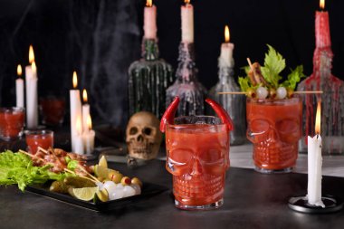 Ürkütücü Cadılar Bayramı partisi. Meksika Bloody Mary 'si Michelada. Domates suyu, tekila, acı sos, bira bardağında buzla servis edilmiş domuz pastırması, kereviz, zeytin ve soğan turşusuyla süslenmiş.