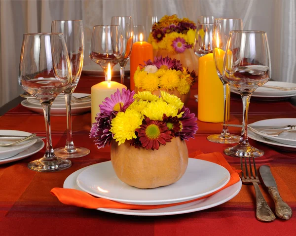 Flores de otoño en un jarrón sobre la mesa con calabaza — Foto de Stock