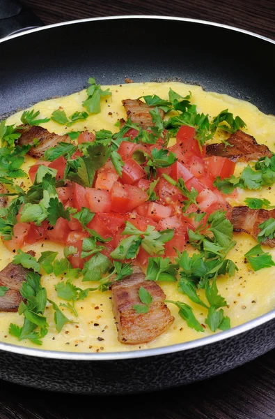 Omeletu plátky slaniny, rajčat s bylinkami — Stock fotografie