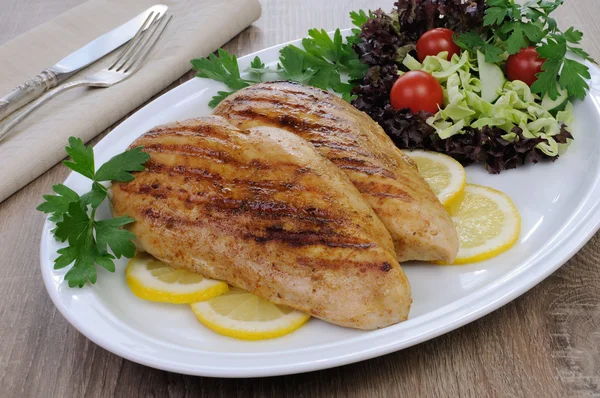 Chicken grilled with a salad on a plate Royalty Free Stock Images
