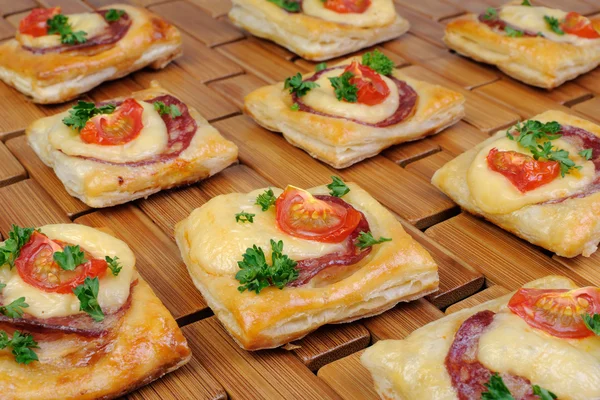 Appetizer of puff pastry with salami — Stock Photo, Image