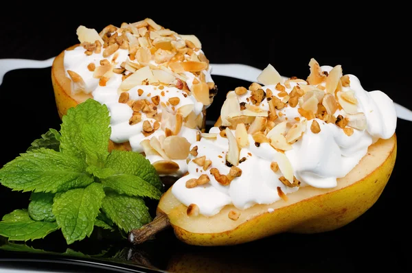 Pear with whipped cream and nuts — Stock Photo, Image