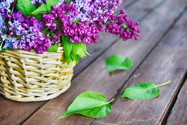 Basket with branch of lilac — Stock Photo, Image