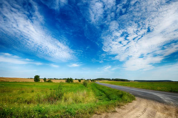 Estrada rural entre campos — Fotografia de Stock