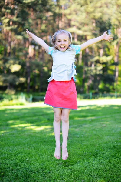 Little  happy  girl on green lawn. — Stock Photo, Image