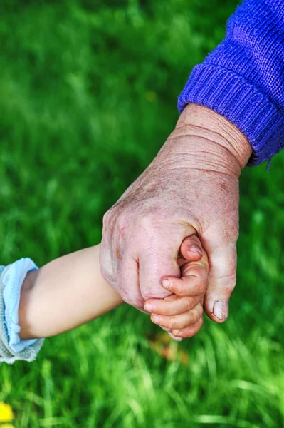 Abuela sostiene la mano de los niños — Foto de Stock