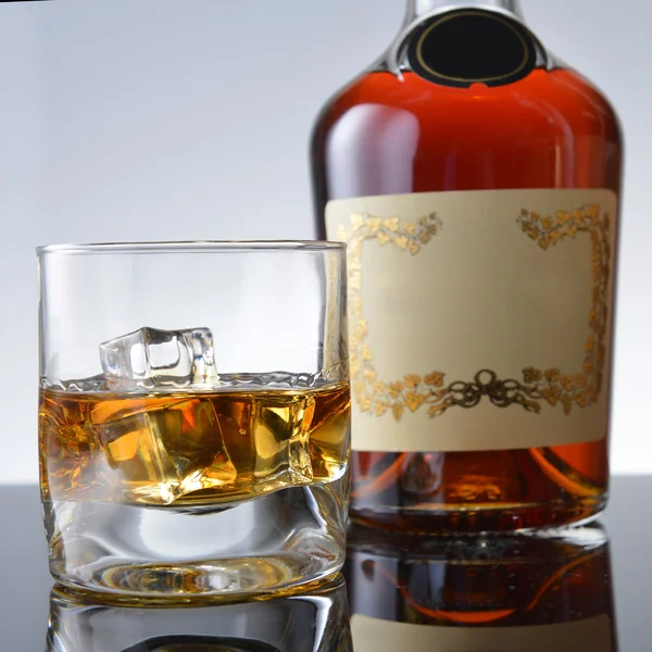 Glas en fles met whisky — Stockfoto