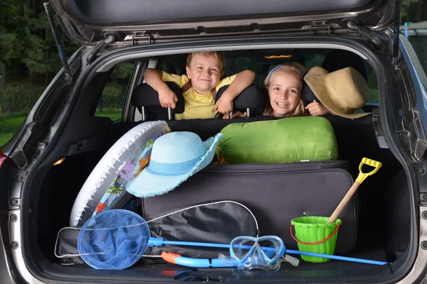 Meisje en haar broer zitten in auto — Stockfoto