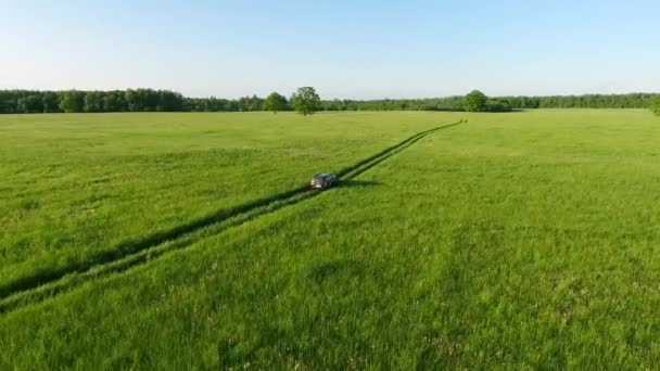 Vista aérea del coche todoterreno moviéndose por carretera en campos verdes — Vídeo de stock