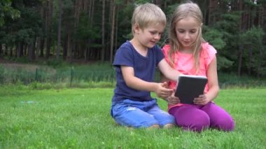 açık havada tablet ile oynayan iki çocuklar