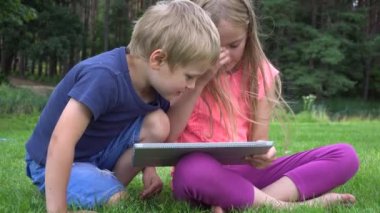 açık havada tablet ile oynayan iki çocuklar