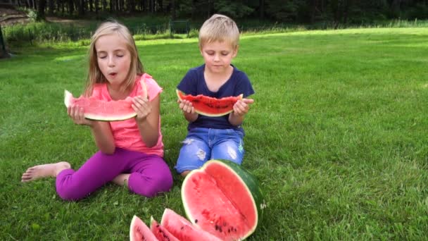 Kinderen eten buitenshuis watermeloen — Stockvideo