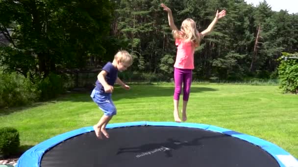 Двое детей прыгают на батуте — стоковое видео