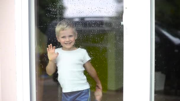 Хлопчик стоїть всередині будинку — стокове відео