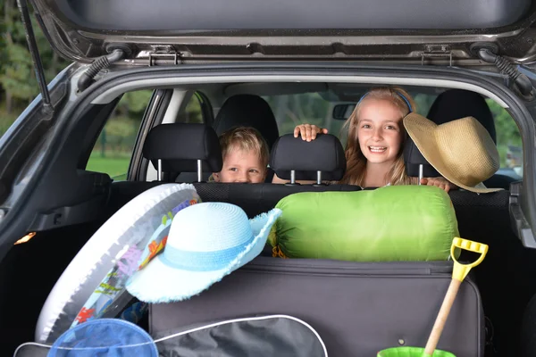 Klein meisje en jongen zitten in auto — Stockfoto