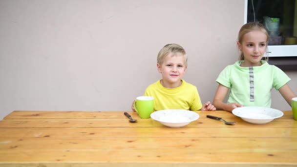 Два симпатичных ребенка едят — стоковое видео