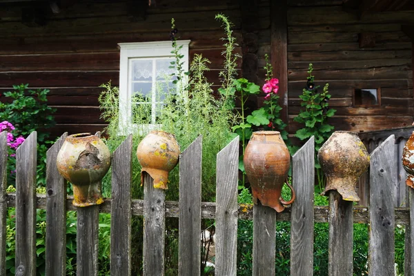 Old jugs on fence — Stock Photo, Image