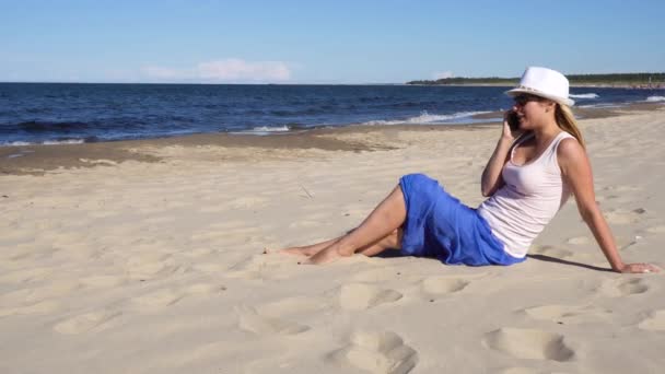 年轻的女孩子说话的手机在海滩上 — 图库视频影像