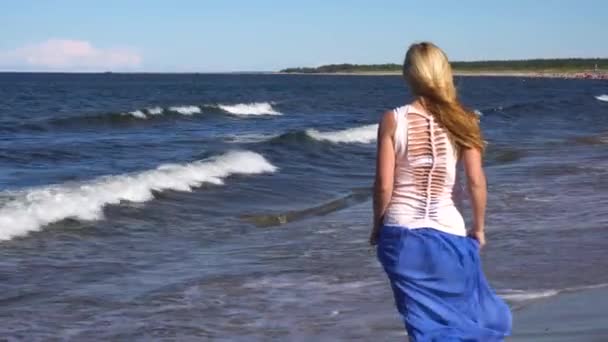 Jonge vrouw wandelen op het strand — Stockvideo