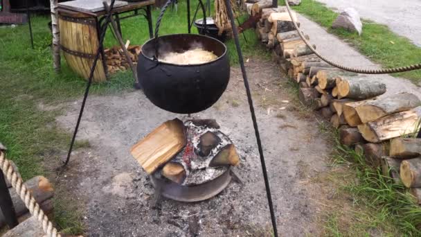 Cocinar en una caminata en el caldero colgando sobre el fuego — Vídeo de stock