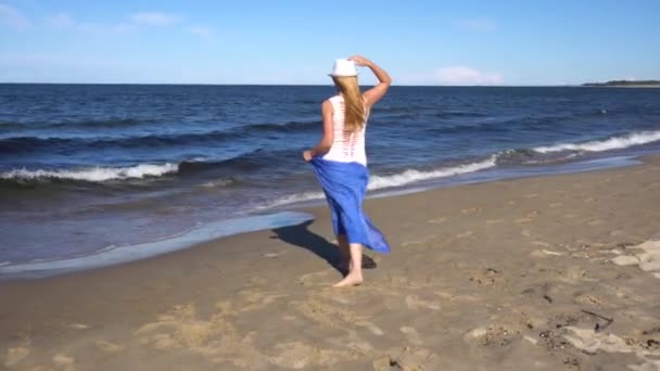 Jonge vrouw wandelen op het strand — Stockvideo