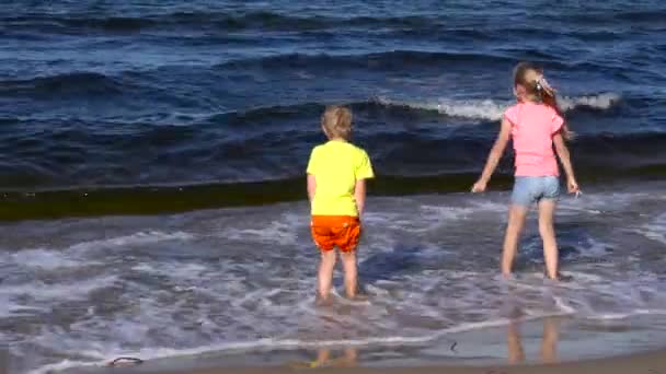 Niños jugando en la playa — Vídeo de stock