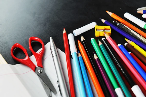 School supplies on blackboard — Stock Photo, Image