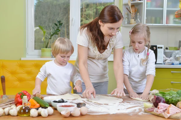 Moeder met kinderen voorbereiden pizza 's — Stockfoto