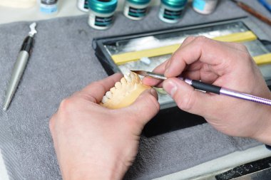 Diş teknisyeni takma diş üzerinde çalışma