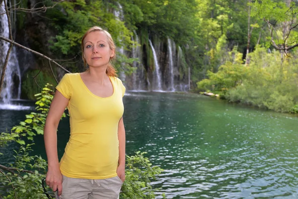 Giovane donna vicino alle cascate — Foto Stock