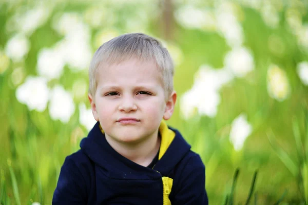 Kleine jongen in de buurt van narcissen — Stockfoto