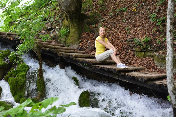 Junge Frau in der Nähe von Wasserfällen — Stockfoto
