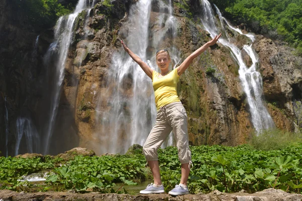 Женщина возле водопадов и гор — стоковое фото