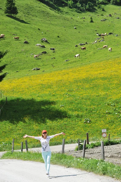 Kvinna och betesmarker med kor — Stockfoto