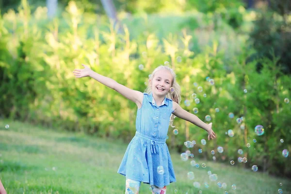 Girl plays with bubble blower — Stock Photo, Image