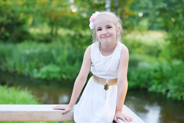Милая маленькая девочка в белом платье — стоковое фото