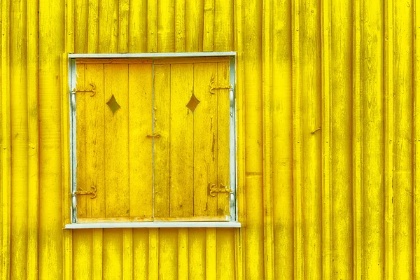 Окно покрыто желтыми ставнями — стоковое фото
