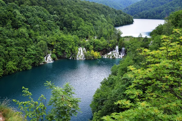 Jezero v horách s vodopády — Stock fotografie