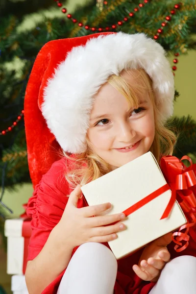 Meisje in santa cap met cadeau — Stockfoto