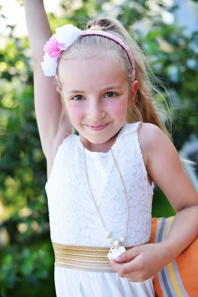 Kleines Mädchen im weißen Kleid im Park Stockbild