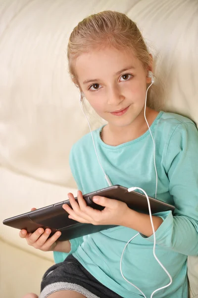 Meisje op de Bank en het gebruik van een Tablet PC — Stockfoto