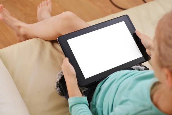 Chica en el sofá y el uso de tabletas — Foto de Stock