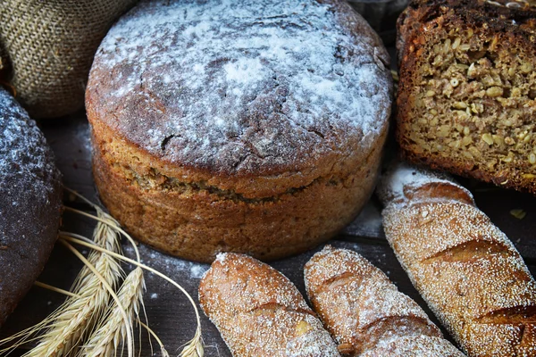 Bread loaves, buns and wheat — Stock Photo, Image