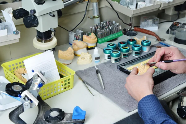 Dental technician working on false teeth — Stock Photo, Image