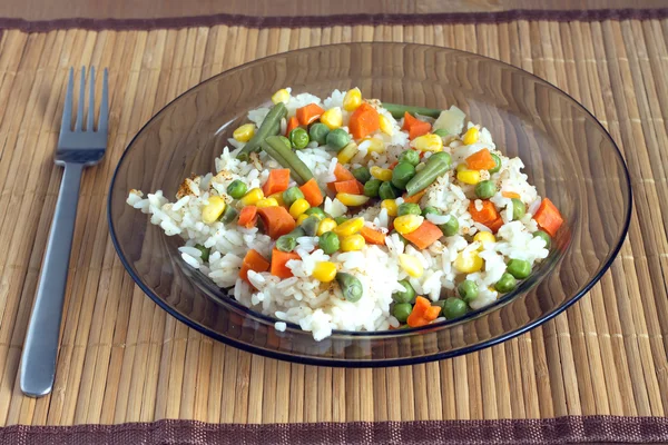 Arroz blanco con verduras en plato sobre estera de mimbre — Foto de Stock