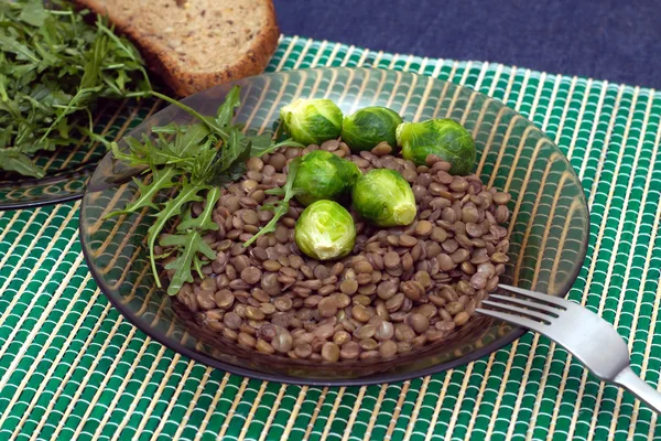 レンズ豆、ブロッコリー、ルッコラのサラダ葉粒パン、プレート上 — ストック写真