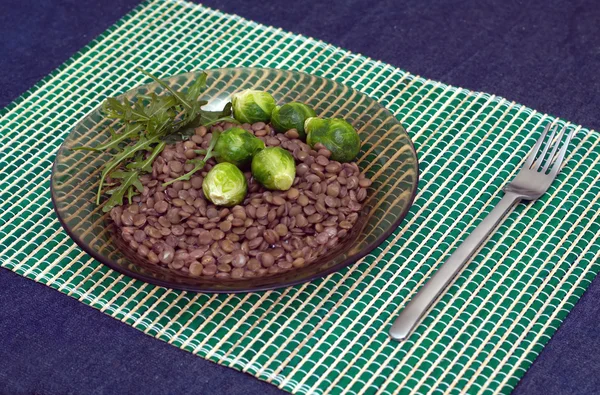 Lentilhas, brócolis e folhas de salada de arugula em umas chapas — Fotografia de Stock