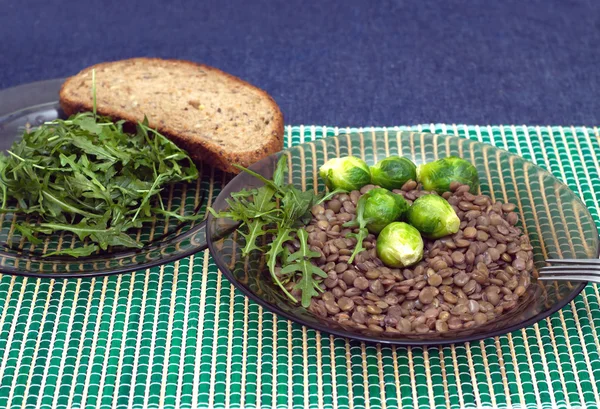 Lentilhas, brócolis e salada de arugula folhas com pão de grão em umas chapas — Fotografia de Stock