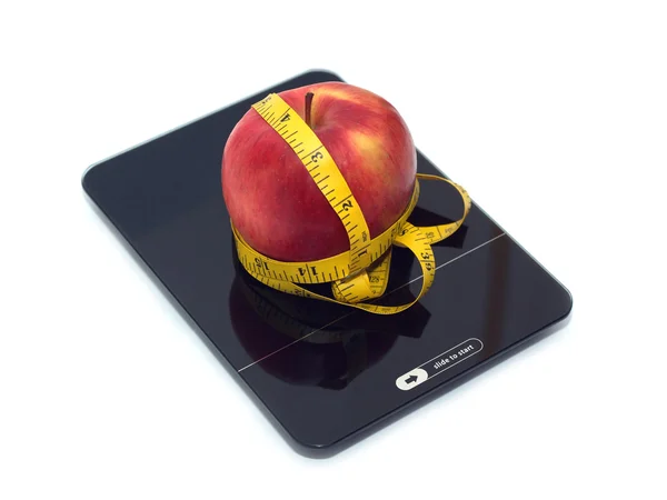 Red apple on kitchen scales with measuring tape isolated closeup — Stock Photo, Image