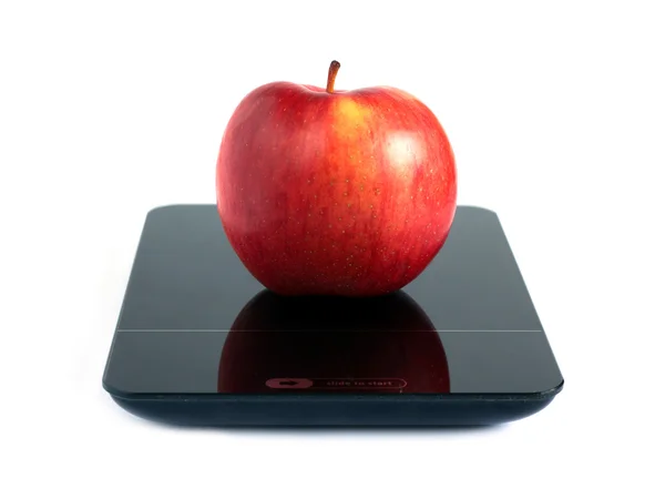Červené jablko na kuchyňské váhy izolovaných na bílém closeup — Stock fotografie